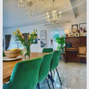 a dining room with a table and green chairs at Villa Andrea in Zagvozd