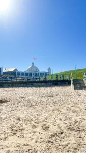 a pier on the beach with a building in the background at Luxury seaside getaway Whitley Bay in Whitley Bay