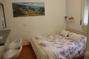 een kleine kamer met een bed en een schilderij aan de muur bij Monika Holiday 302 Joy in the lake in Garda +103 foto's