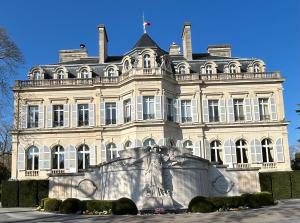 a large white building with a statue in front of it at Ecolodge "Les Treilles Monet" Gîte insolite en Champagne à proximité d'Epernay in CumiÃ¨res