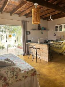 a bedroom with a bed and a kitchen with a table at Villa Madeira in Alto Paraíso de Goiás