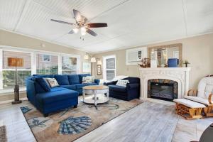 a living room with a blue couch and a fireplace at Suncatcher Cottage 1508-2nd Avenue B in Tybee Island