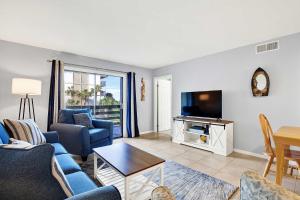 Una sala de estar con un sofá y un televisor. en Lighthouse Point Rental 34A, en Tybee Island