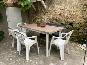 Sainte-EulalieMaison RASSIER, Gîte Vélo的一张桌子、四把椅子、一张桌子和一面墙