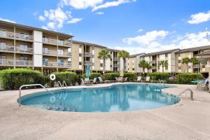 una piscina en un patio con un edificio en Lighthouse Point Rental 34A, en Tybee Island