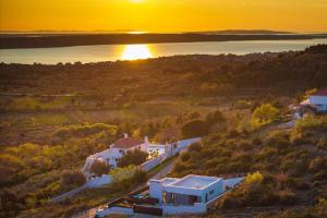 an aerial view of a house with the sunset in the background at MY DALMATIA - Sea view Villa Rica in Podvršje