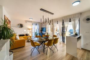 a dining room and living room with a table and chairs at MY DALMATIA - Sea view Villa Rica in Podvršje