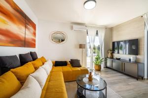 a living room with a yellow couch and a tv at MY DALMATIA - Sea view Villa Rica in Podvršje