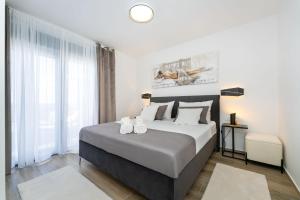 a bedroom with a bed with two shoes on it at MY DALMATIA - Sea view Villa Rica in Podvršje