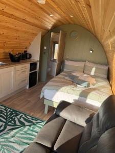 a bedroom with a large bed and a kitchen at Killee Luxury pod and private hot tub in Coa