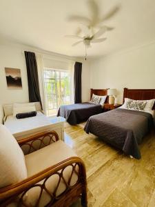 a bedroom with two beds and a ceiling fan at Apartamento en Punta Cana, White sands in Punta Cana