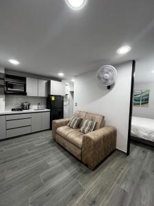 a living room with a couch and a kitchen at Apartamento Moderno, Comodo, Cerca al Aeropuerto in Pereira