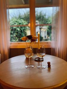 two wine glasses and a candle on a table with a window at Villa Sol B&B and Hostel in Borgholm +28 photos