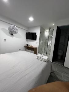a bedroom with a white bed and a tv on the wall at Apartamento Moderno, Comodo, Cerca al Aeropuerto in Pereira +5 photos