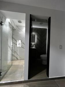 a bathroom with a toilet and a glass door at Apartamento Moderno, Comodo, Cerca al Aeropuerto in Pereira