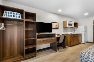 a hotel room with a desk and a computer and a kitchen at WoodSpring Suites Palmdale - Lancaster in Palmdale