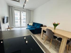 a living room with a table and a blue couch at Wygodne Mieszkania Nova Mikołowska Apartamenty in Katowice