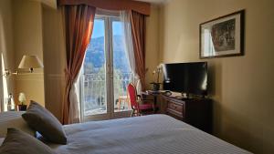 ein Hotelzimmer mit einem Bett und einem großen Fenster in der Unterkunft Hotel Funicolare in Lanzo dʼIntelvi