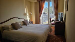 ein Hotelzimmer mit Bett und Balkon in der Unterkunft Hotel Funicolare in Lanzo dʼIntelvi
