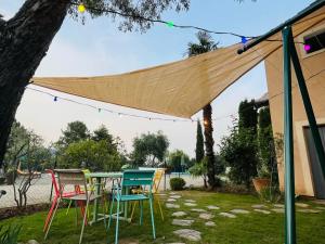 a table and chairs under a canopy in a yard at Gîte Le Planzollais in Planzolles +30 photos