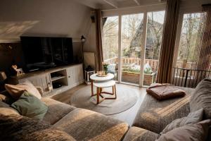 a living room with a couch and a table at Het Hertenbos Chalet 136 - Bos- Groene Oase- Rustmoment- Zwembad in Durbuy