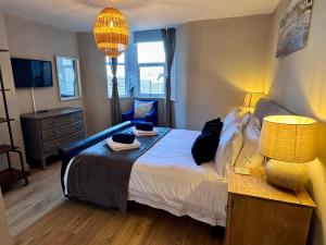 a bedroom with a bed with a lamp and a chair at Purbeck Hill View in Swanage