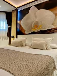 a bed with a large white flower on the wall at El Jardin in Soto de la Marina