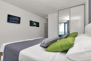 a bedroom with a large white bed with green pillows at Villa Nera-Selina in Makarska +23 photos