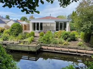 a house with a pond in front of it at Bungalow in Makkum near Lake Beach in Holle Poarte
