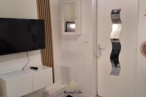 伊西莱穆利诺Appartement Studio, 2 Personnes, 5min de Paris的客厅配有平面电视和镜子