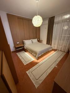 a bedroom with a bed and a chandelier at Ilio's Apartment in Sarandë