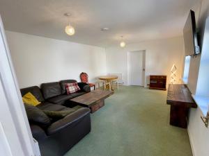 a living room with a couch and a table at Vernon Place town centre, Vernon Cottage 3-bed with parking, 1A Vernon Court 2-bed with parking, 1B studio no parking, off the High Street next to Sandford Park in Cheltenham