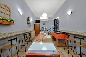 a room with a bar with a table and stools at HOTEL & HOSTEL RIBEIRAo in Ribeirão Preto