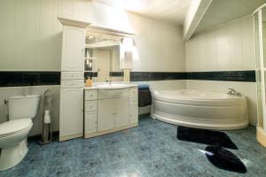 a bathroom with a tub and a toilet and a sink at Nickson & Dido Appartement lumineux à Saumur 5 min du centre-ville in Saumur