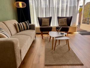 a living room with a couch and two chairs and a table at Reumann Holiday Apartments De Schelp 12 in Zandvoort