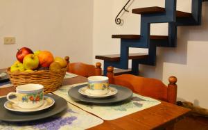 uma mesa com duas chávenas e uma cesta de frutas em Poggio Borgoni em Mercatale Val Di Pesa