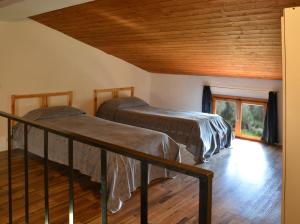Duas camas num quarto com tecto em madeira em Poggio Borgoni em Mercatale Val Di Pesa