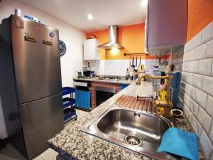 a kitchen with a sink and a stainless steel refrigerator at O Ninho in Cepos