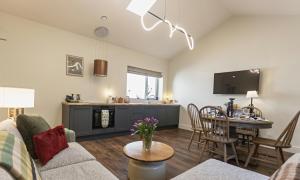 a living room with a couch and a table and a kitchen at Castlestone Holiday Cottages & Townhouses in Naas