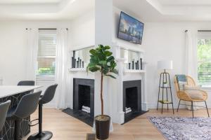 a living room with a fireplace and a table and chairs at Elegant 2 BR apt in the heart of historic SPR - 5 min drive to TIAA Bank Field in Jacksonville