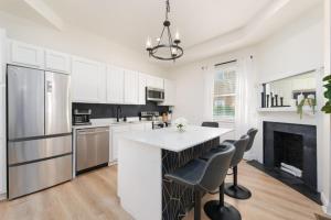 a kitchen with a white counter and a fireplace at Elegant 2 BR apt in the heart of historic SPR - 5 min drive to TIAA Bank Field in Jacksonville
