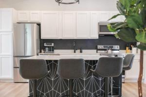 a kitchen with a kitchen island with four chairs at Elegant 2 BR apt in the heart of historic SPR - 5 min drive to TIAA Bank Field in Jacksonville