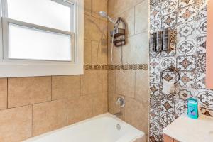 Un baño con bañera y ducha con ventana. en 3 Mi to French Quarter Retreat with Private Yard, en Nueva Orleans 16 fotos más