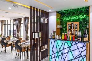 Executive Hotel and Suites في إيكيجا: مطعم بطاولات وكراسي وجدار أخضر +16 صورة
