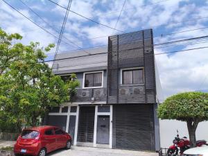 una casa con un coche rojo estacionado frente a ella en Hotel Tazumal House, en San Salvador
