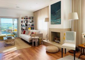 a living room with a white couch and a fireplace at Pomar da Choca Country House in Alenquer