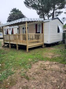 a mobile home with a porch and a deck at Mobil Home Charente-Maritime camping LA PIGNADE in La Tremblade
