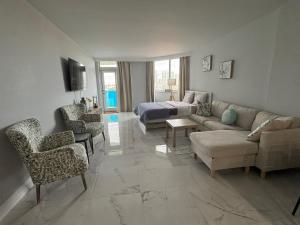 a living room with a couch and a bed at Modern Apartments Ocean Reserve Sunny Isles Beach in Sunny Isles Beach