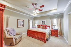 Schlafzimmer mit einem Bett, einem Stuhl und einem Deckenventilator in der Unterkunft Private Dock The River House in Heber Springs! in Heber Springs