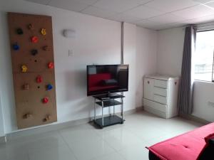 a room with a tv and a climbing wall at Amplio y aconchegante in Huaraz